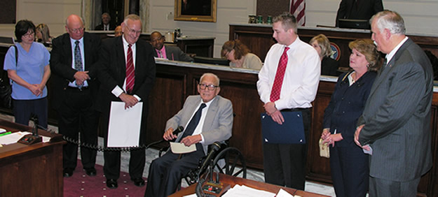 Colonel Perry Woolridge addresses the Senate after the reading of SR 58 honoring his military career alongside his family, Secretary of Veterans Affairs Norman Lamb and Sen. Earl Garrison. 
