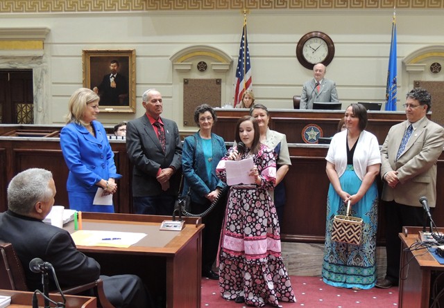 Sen. Kim David looks on while 14-year-old Cierra Fields addresses Senate , in both Cherokee and English, surrounded by her family.